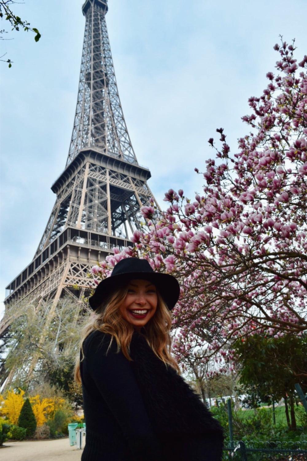 Girl smiling in front of Eiffel Tower in Paris