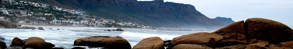 Coastline of Cape Town with rocks and the city in the distance