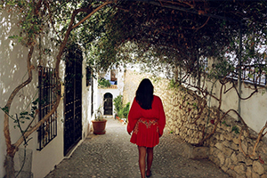 Woman walking down Spanish cobblestone street