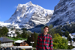 Student in Swiss valley surrounded by snowy mountains