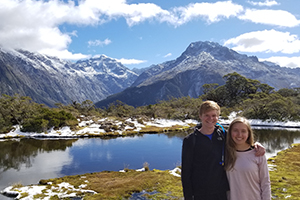 Students with New Zealand lake and mountains behind