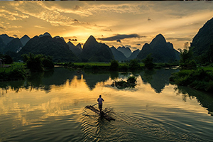 Man rafting into lake with mountains in the distance