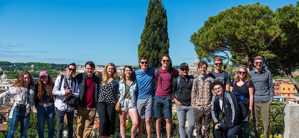 Students posing for a group photo in a Roman park