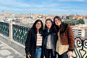 Students posing on a balcony overlooking Lisbon