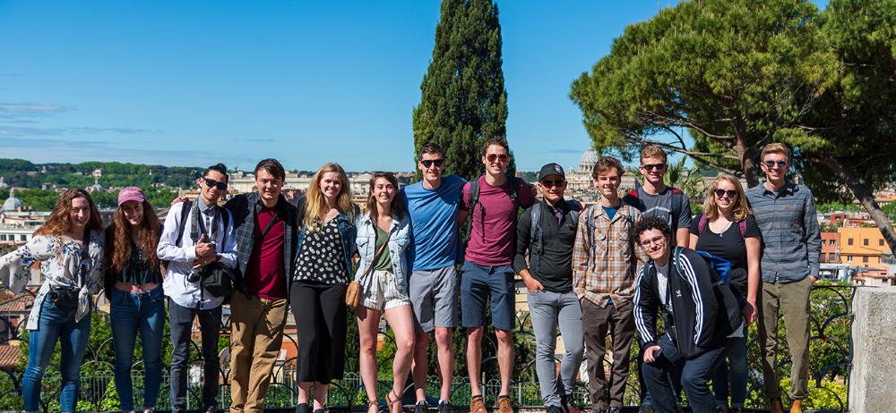 Group in front of Italian city backdrop on a sunny day, photo by Connor Shaver