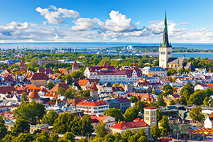 Cityscape of Talinn Estonia with red roofs, trees, and coast